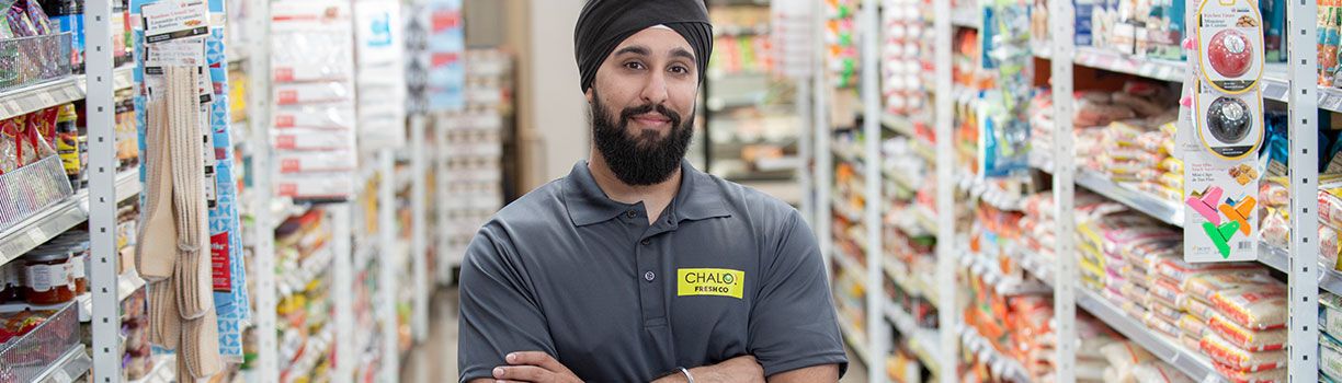 Chalo Freshco employee standing in store aisle