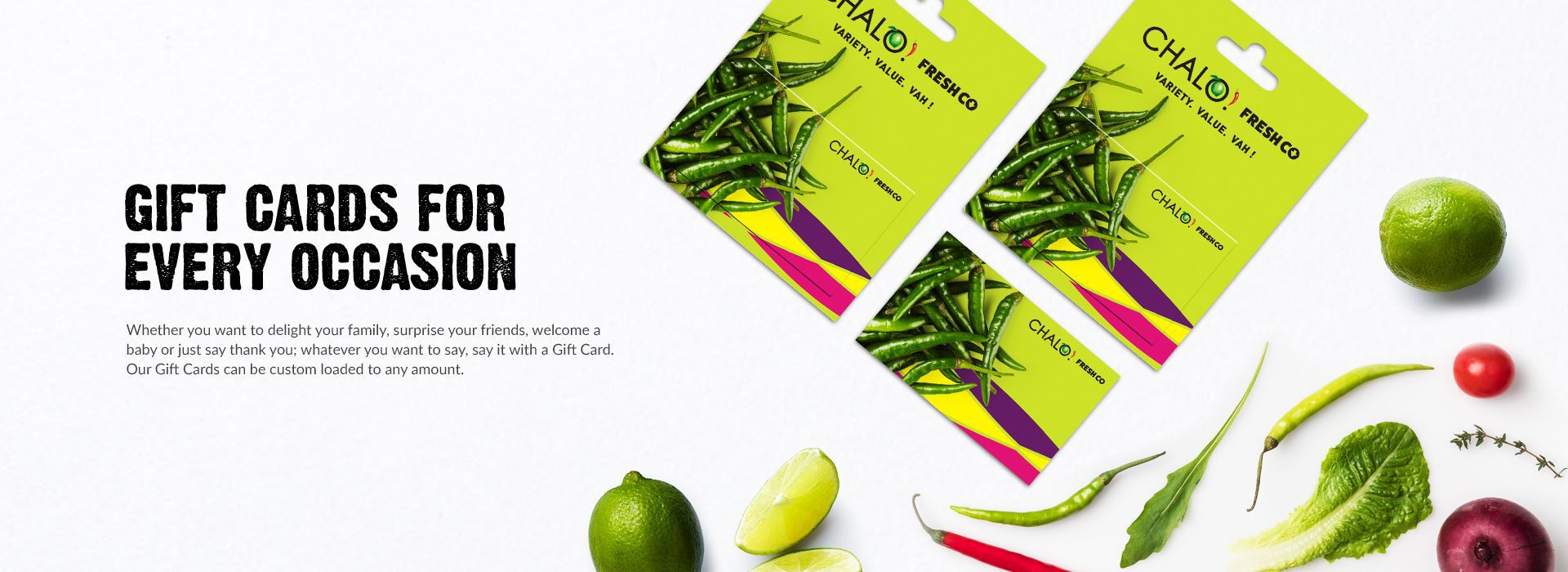 A promotional image featuring two gift cards from Chalo Freshco on a green background surrounded by various green vegetables and fruits. On the left, bold text reads, "Gift Cards for Every Occasion," with a smaller descriptive paragraph below.